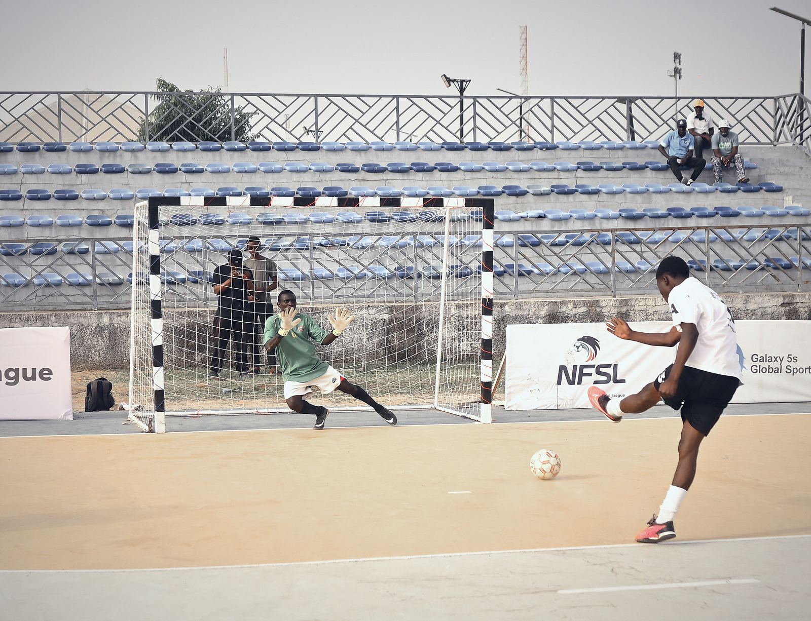A player striking at goal with the keeper committed
